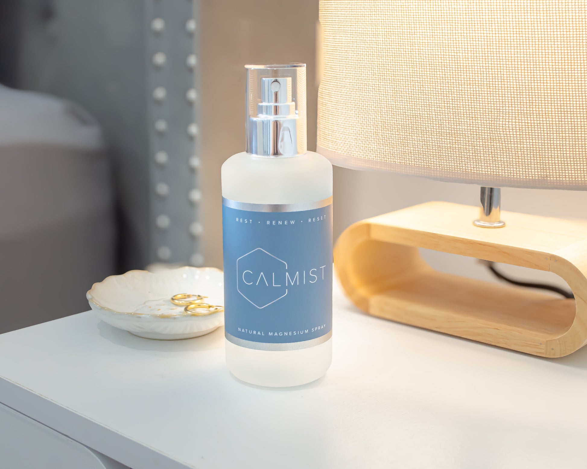 Bottle of 'CALMIST' on a nightstand next to a lamp